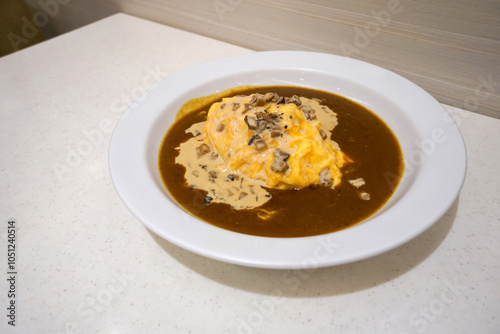 Creamed Mushroom Omelet Curry.   Curry rice served in white ceramic plate. Spicy food in Japanese restaurant.
