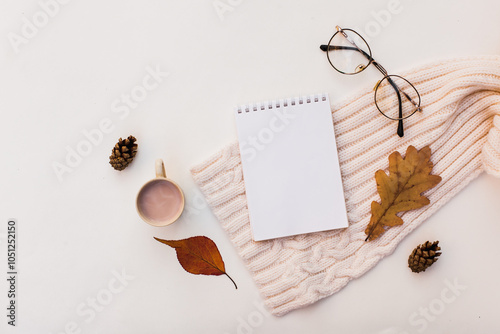 Workspase with notebook, glasses, cozy scarf and cup of coffee with milk on white wooden background. Autumn creative composirion flat lay. Work, online education, goals to do list, home office concept photo