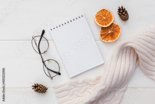 Workspase with notebook, glasses, cozy scarf and cup of coffee with milk on white wooden background. Autumn creative composirion flat lay. Work, online education, goals to do list, home office concept photo