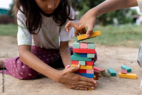 Indian girls playing together stack block game in the steet photo