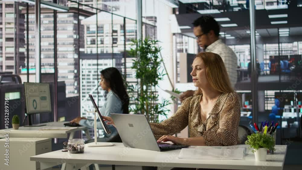 Professional manager at a multinational company works on laptop to track project progress and deadline completion. Office worker ensuring smooth task management and decision making. Camera B.