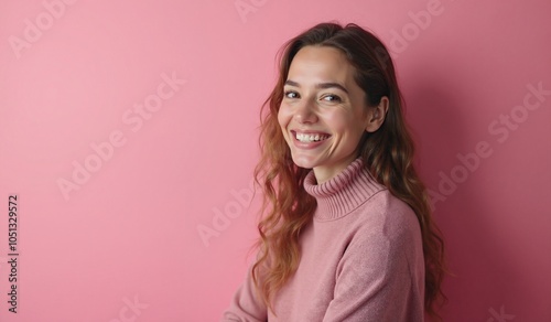 Woman with radiant smile wearing pink sweater against pink background with copy space