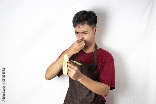 teenage bartender smells rancid aroma from his peeled banana