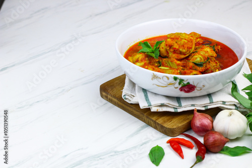 Ayam Rica-Rica, traditional Indonesian hot and spicy braised chicken. White marble background, selected focus.