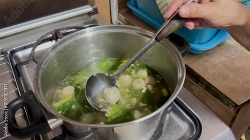 Video of a person stir and making preparation of soup meatballs. Common soup in Indonesia often become dish for a lunch or dinner photo