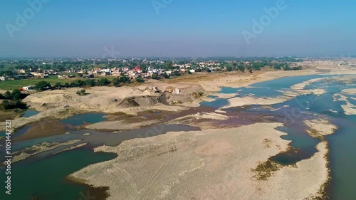 The whole town full of small green bushy trees, houses and mountain ranges on a sunny day in Pakistan photo