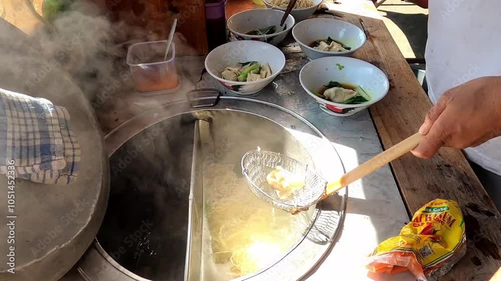 Preparing chicken noodles. View of a penjual mie ayam bakso or meatball chicken noodle seller who is making chicken noodles for the buyer. Close Up
