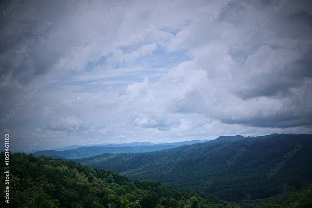 Obraz premium A stunning view of verdant mountains under a cloudy sky.