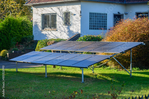 Solar panels, mounted on the ground in the yard of a residential home, efficiently capture sunlight to generate renewable energy. photo