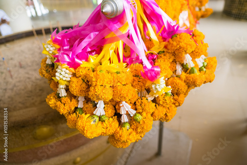 Vibrant Marigold Garlands with Colorful Ribbons Hanging in a Thai Temple, Symbolizing Faith and Tradition in Thai Culture photo