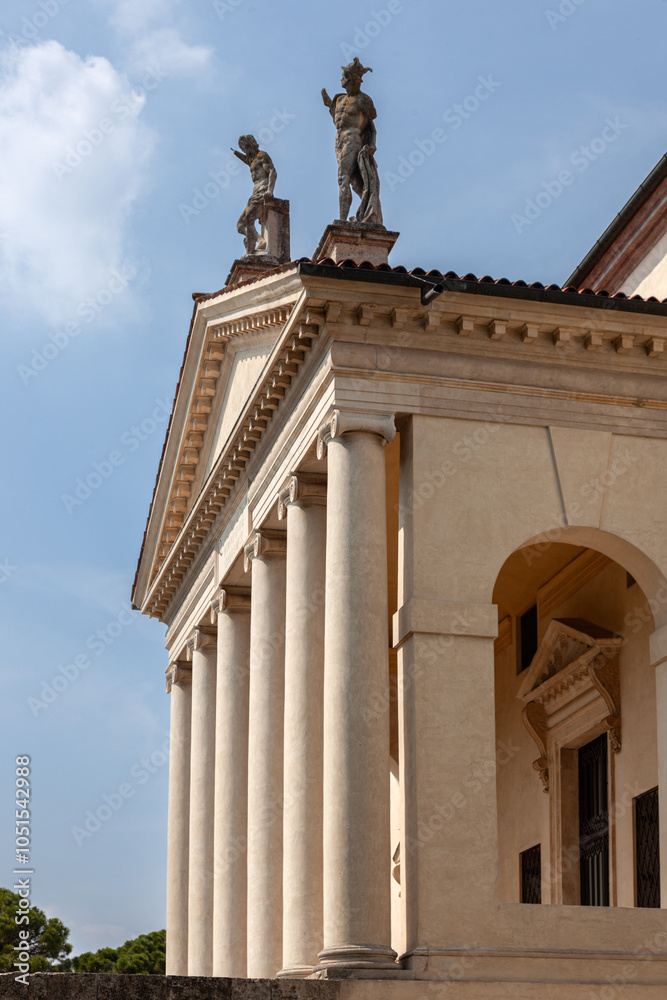Fototapeta premium This grand villa showcases Palladian architecture with a stately colonnade, sculpted statues on the roofline, and arched entrances. A serene garden and central well enhance the classical ambiance.