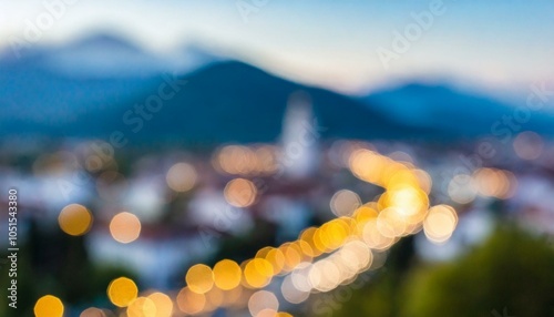 Bokeh lights of a town with mountains in the background.