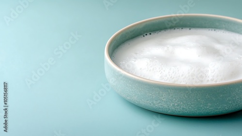 Delightful creamy foam in a beautiful bowl against a soft turquoise background for a refreshing drink experience