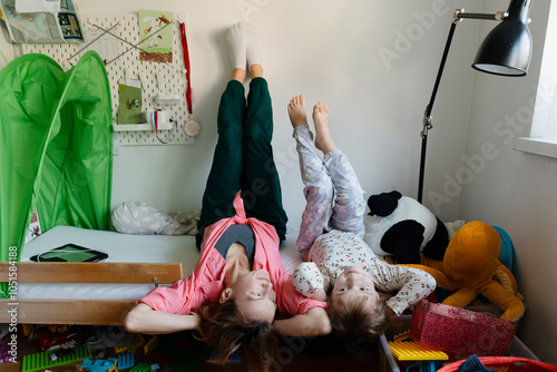 Mother and boy lying upside down on bed at home photo