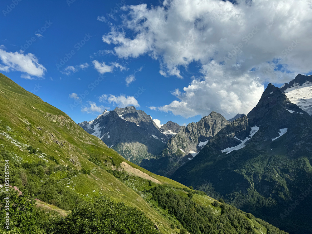 Obraz premium Mount Dombay-Ulgen view from the Dombay village. Sunny summer day. Karachay-Cherkessia, Russia. Caucasus Mountains is a tourist destination.