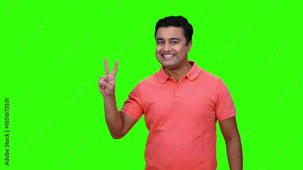 A young male model is happy and successful showing victory gestures. Chroma key,green screen. A young male model is happy and successful showing victory gestures. Chroma key,green screen.