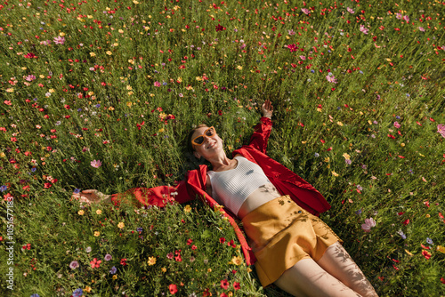 Happy woman lying on flowering plants in field