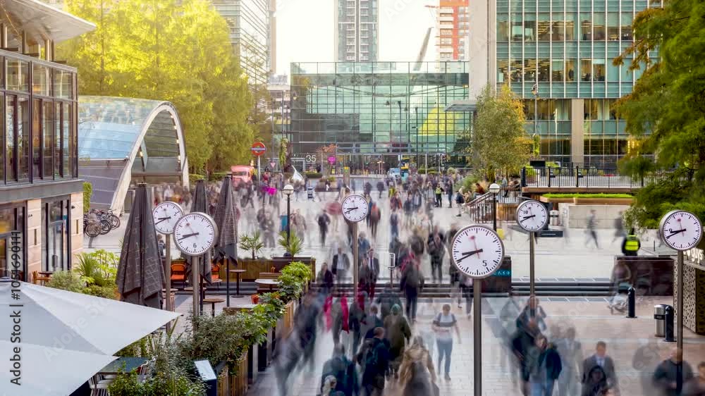 Sunrise timelapse view of motion blurred business people rushing to work in the moring at the financial centre Canary Wharf, London