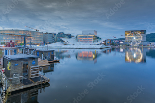 View of saunas, Oslo Opera House and Munch Museum reflecting in harbour on cloudy evening, Oslo, Norway, Scandinavia, Europe photo