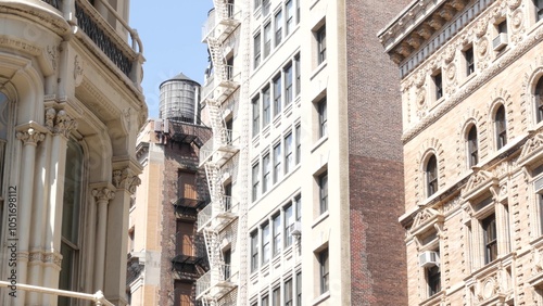 New York City Broadway, Manhattan midtown classic building corner architecture. Urban residential house exterior. Real estate property in USA. Typical brick facade. Rooftop water tower, tank on roof. photo