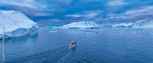 Aerial of a boat between the icebergs of the Ilulissat Icefjord, UNESCO World Heritage Site, Western Greenland, Denmark, Polar Regions photo