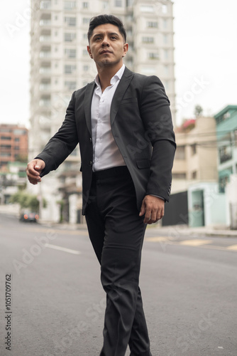 Young man with short hair walking in the city, wearing a suit with a shirt, elegant fashion and style, city background with buildings, modern business person