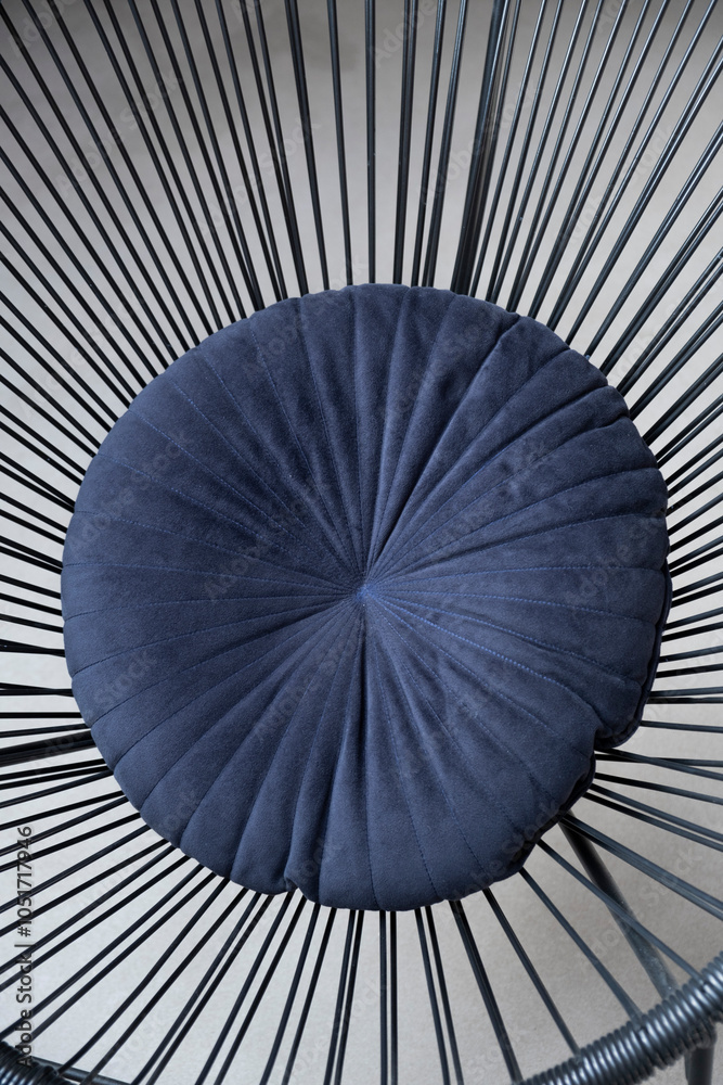 Obraz premium Armchair. Dark metal armchair. Blue cushion on the chair. Minimalistic design. Detail. Interior. Counter. Construction. Concrete background. Concrete walls. Furniture