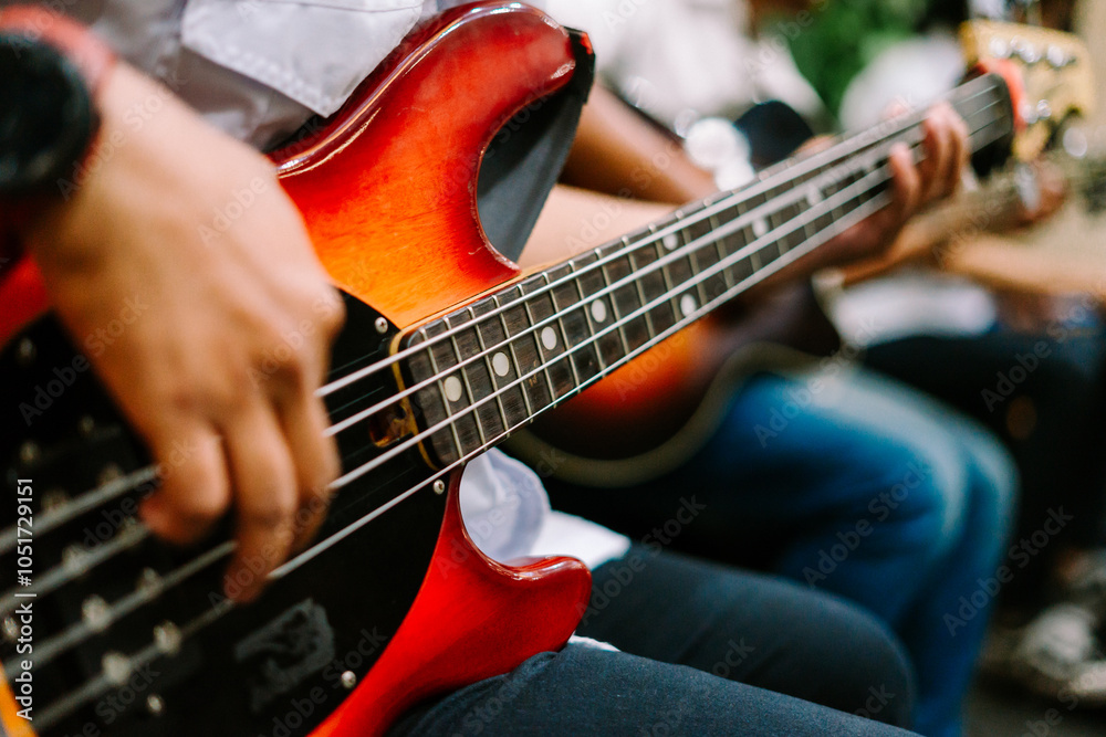 Fototapeta premium A musician passionately playing an electric bass guitar, showcasing skill and rhythm