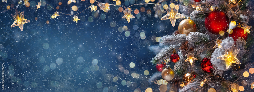 Christmas tree with Christmas balls on the background of the night sky - decorations on fir branches with shiny and unfocused lights and snowflakes on an abstract background