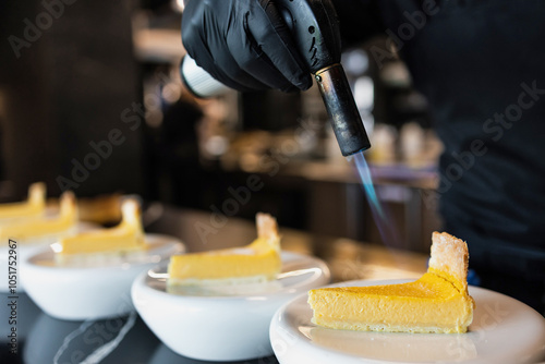 Chef using culinary torch to caramelize lemon tart slices