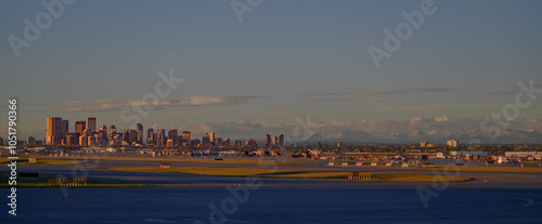 Calgary skyline at sunrise with rocky mountains in the background, panoramic landscape shot from the airport