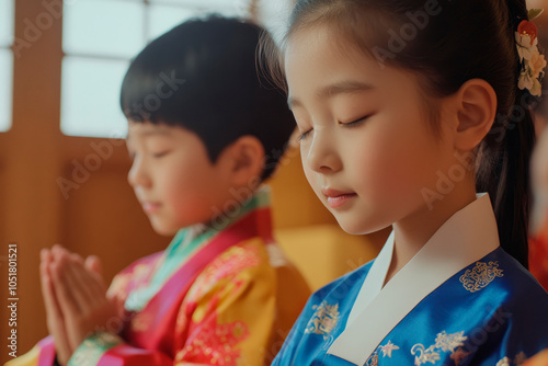 Children in hanbok meditating with eyes closed for cultural ceremony photo