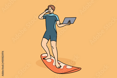 Business man works standing on surfboard, with laptop and mobile phone in hands. Happy guy in diving suit uses surfboard and freelancing gadgets at same time, working while on vacation.