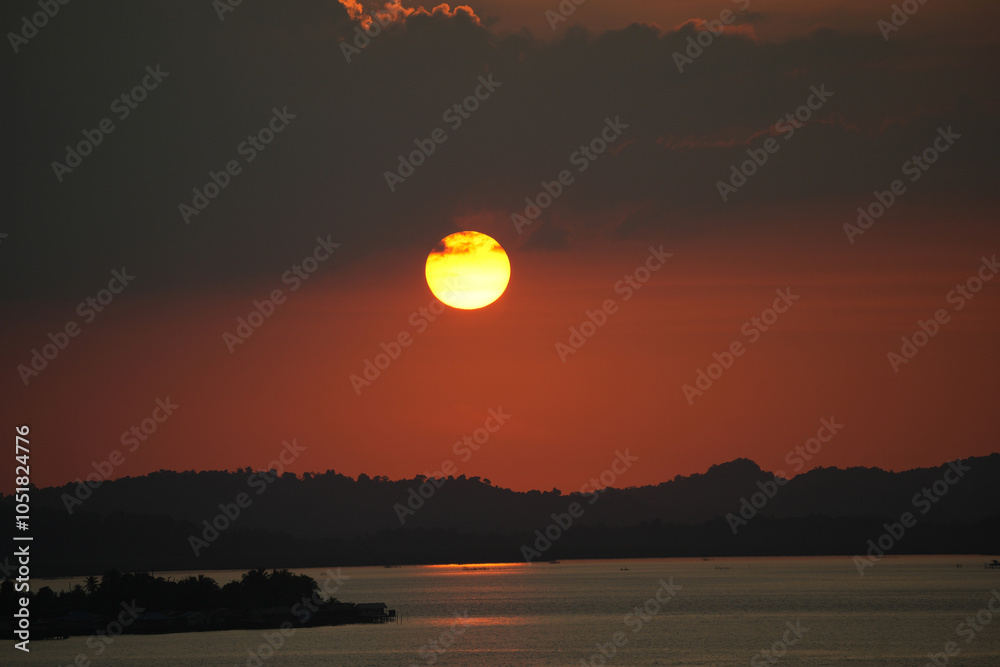 Obraz premium Beautiful sunset stunning sunset descends gracefully behind the rugged mountains, casting warm hues across the landscape. The river below mirrors the vibrant colors, turning