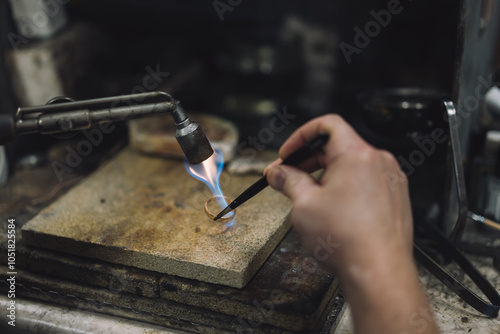 Craftsman is working by using a Gas spraying tool to make a ring