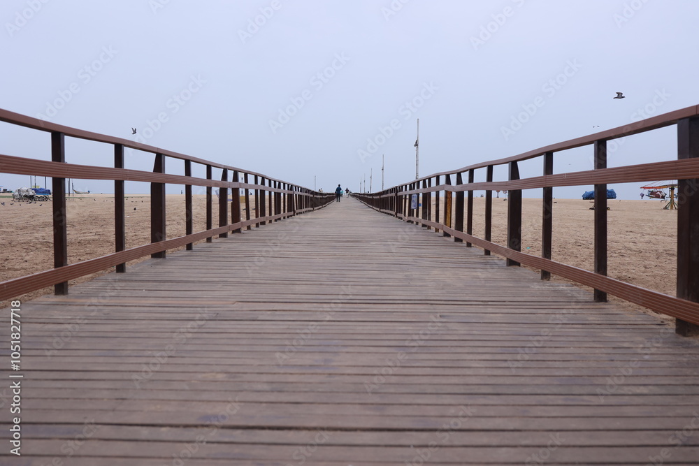 Fototapeta premium Boardwalk wooden pathway at marina beach in Chennai. a ramp for disabled to reach the beach waters