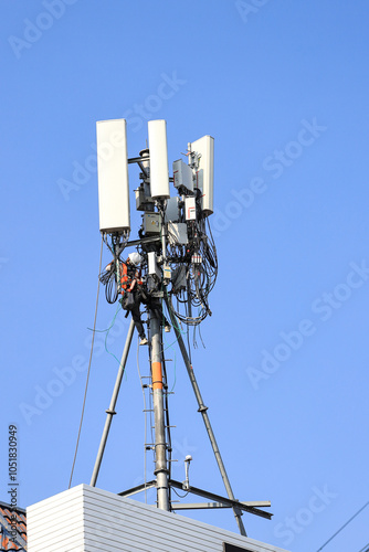 Technician maintenance Wireless Communication Antenna pole or Mobile phone mast antenna pole on top of dilapidated building.
