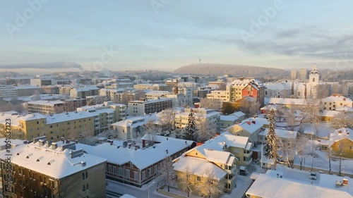 Aerial view backwards over snowy streets of Kuopio city, winter sunrise in Finland photo