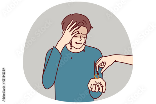 Crying man gets divorced and receives engagement ring from wife who cheated on husband and left for new boyfriend. Depressed husband suffers from depression after divorce and loss of beloved woman