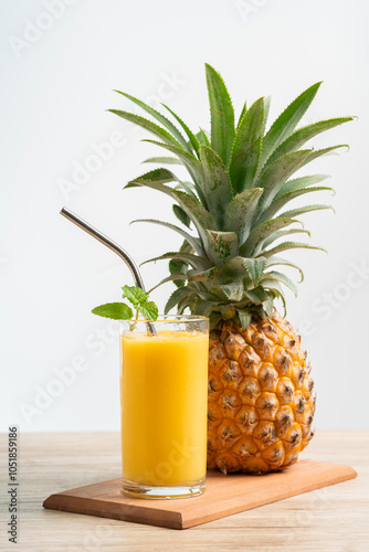 vertical image fresh pineapple smoothie glass on wood table