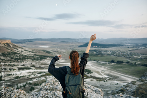 adventure seeker woman triumphantly embracing nature atop majestic mountain peak photo