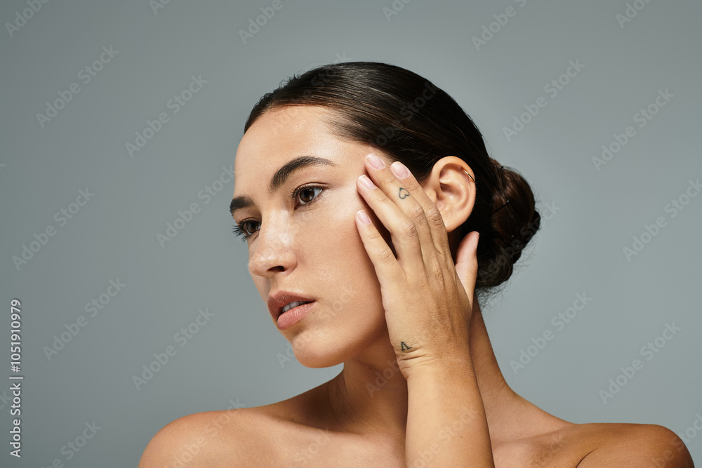A beautiful woman delicately caresses her face, highlighting her elegant features and grace. A beautiful woman delicately caresses her face, highlighting her elegant features and grace.