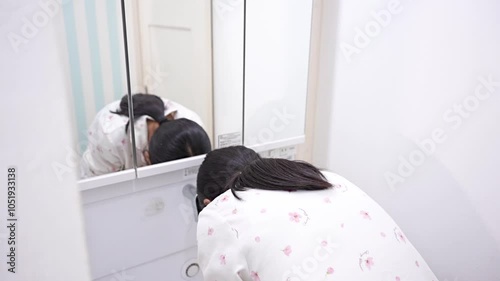 洗面所で洗顔する10代の女性