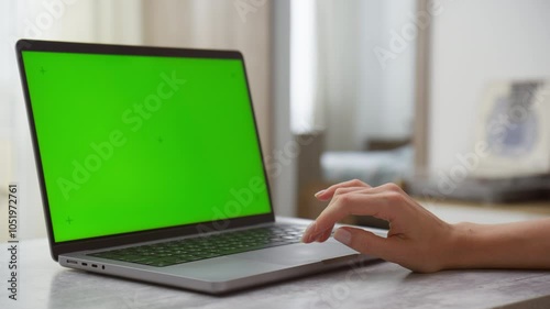 Hand Operating Laptop with Green Screen for Mockup in Bright Room