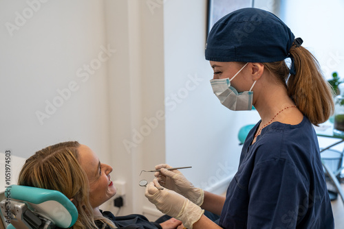 female dentist checking patient girl teeth