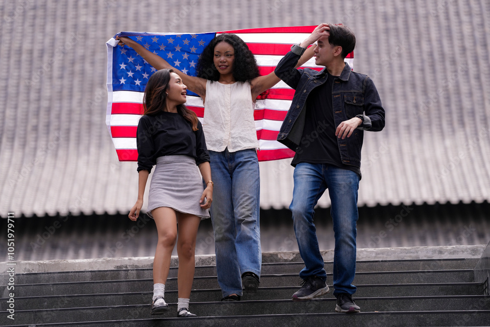 Obraz premium Diverse group of friends proudly holding an American flag outdoors, symbolizing unity and patriotism. Their smiles and casual poses embody freedom, friendship, and the spirit of togetherness.
