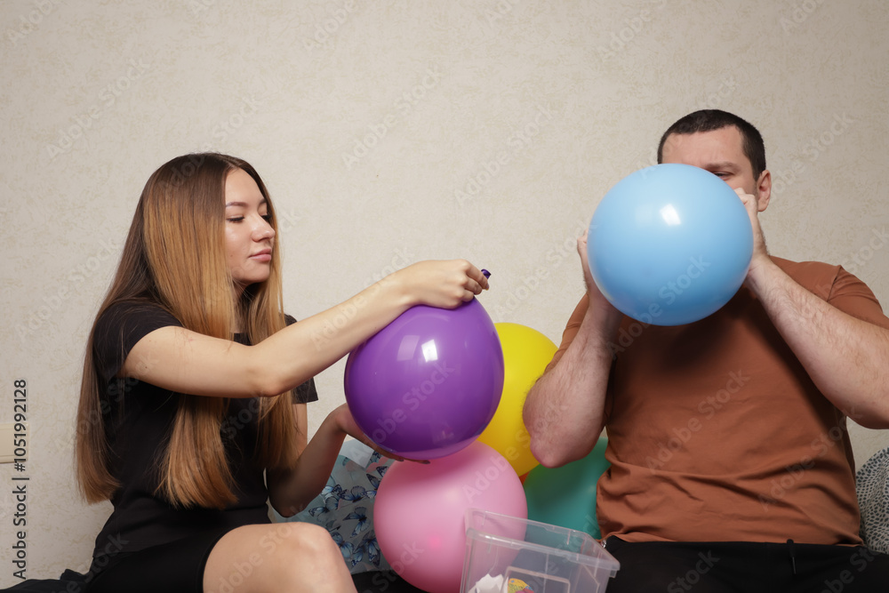 Father and daughter Blowing Up Balloons for Party Decoration, festive home activity of preparing for a party, happiness in decorating with colorful decor. Father and daughter Blowing Up Balloons for Party Decoration, festive home activity of preparing for a party, happiness in decorating with colorful decor.