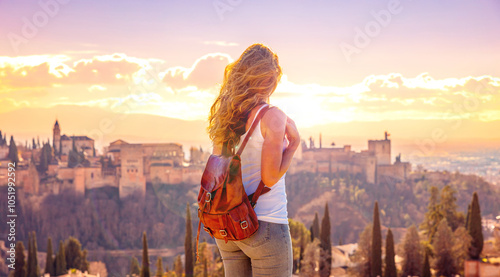 Sunset at Granada city landscape, woman looking at Alhambra, Andalusia in Spain