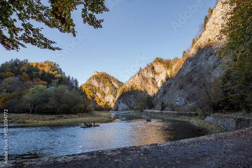 Obraz na płótnie The gorge of the Dunajec River. Rafting down the river. The peaks illuminated by the afternoon sun. Mountains in autumn. Limestone rocks. Szczawnica, Poland w salonie