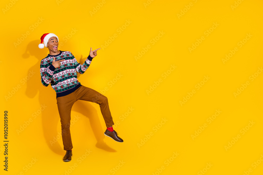 Obraz premium Full size photo of nice young man direct fingers empty space christmas festive time isolated on yellow color background